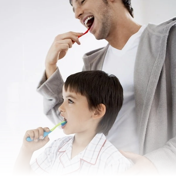 Pai e filho escovando os dentes juntos, incentivando hábitos saudáveis de higiene bucal desde cedo.