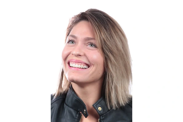 Paciente sorrindo após o tratamento odontológico, mostrando a melhora estética e funcional proporcionada pela reabilitação bucal.