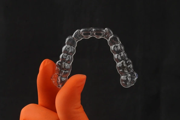 Placa de alinhador invisível, permitindo correção dentária de forma discreta e removível para alimentação e limpeza.
