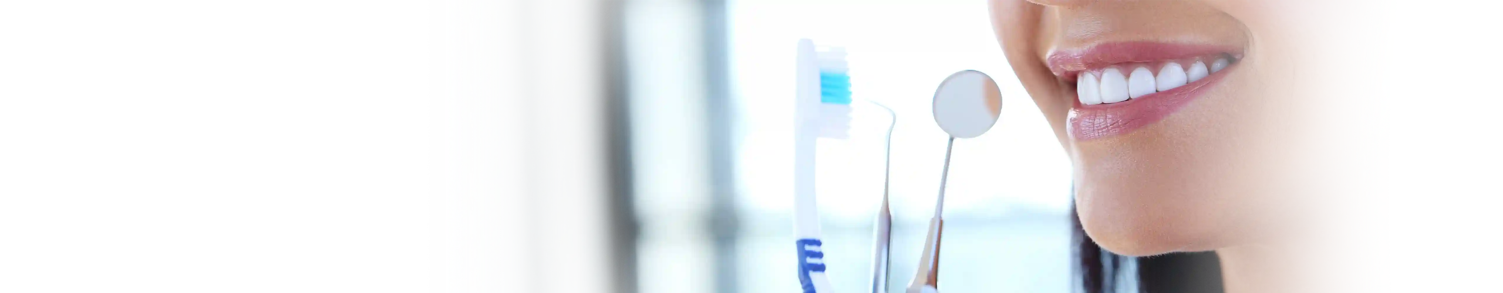 Mulher sorrindo com um sorriso bonito, segurando uma escova de dentes, com um aparelho odontológico em primeiro plano, simbolizando os cuidados essenciais com a saúde bucal.